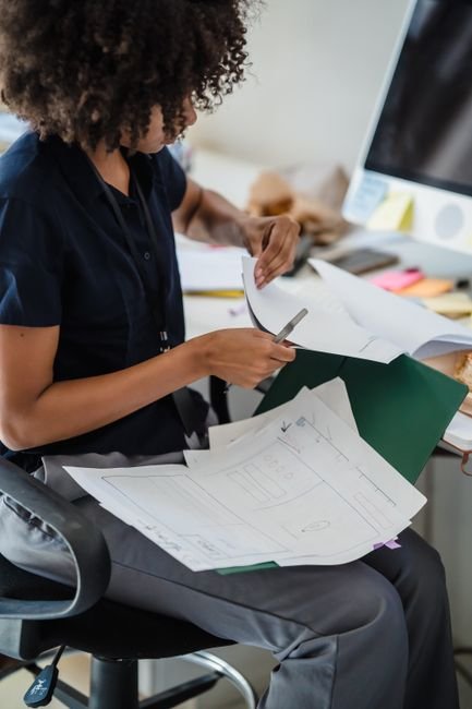 pexels photo 12911215.jpg A focused professional organizing medical billing documents, ensuring workflow efficiency