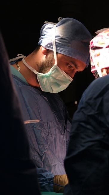 Skilled urologist performing a complex high-value surgical procedure in a sterile operating room