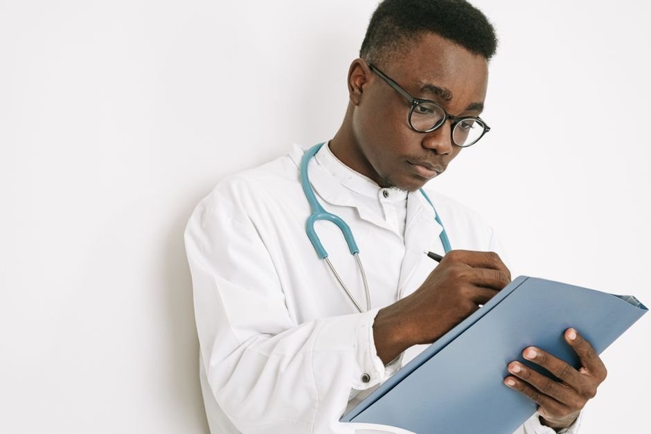 pexels photo 4989132.jpg Doctor writing detailed patient notes for improved clinical note accuracy.
