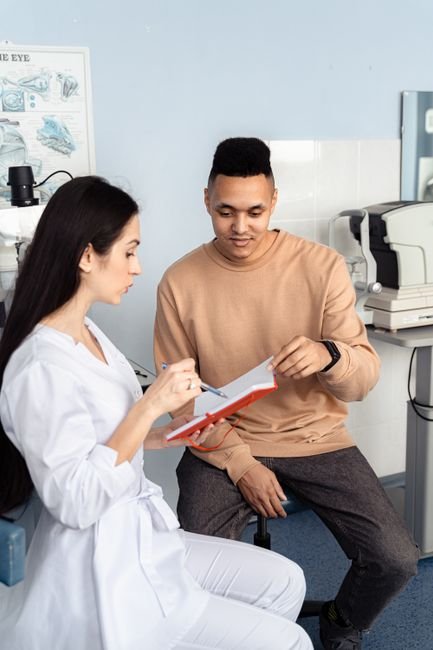 pexels photo 6749754.jpg An ophthalmologist discussing a patient's billing with a staff member in a modern eye clinic setting.
