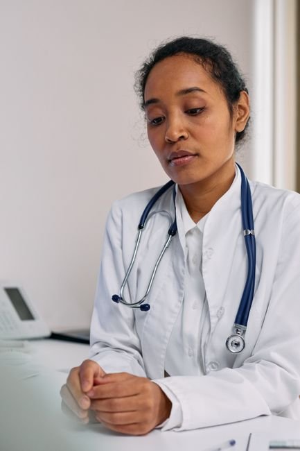 Medical billing specialist diligently reviewing hospice claims documentation on a computer in a modern office.