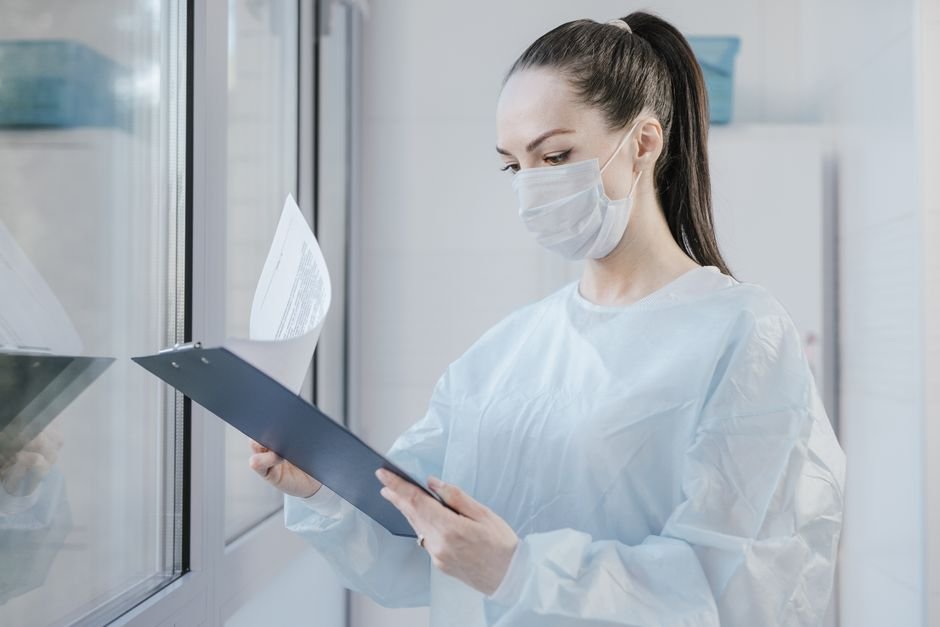 pexels photo 8413398.jpg Home health nurse carefully reviewing patient medical documents for accuracy