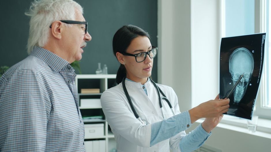 Doctor explaining Medicare billing details and patient responsibilities to an elderly individual.