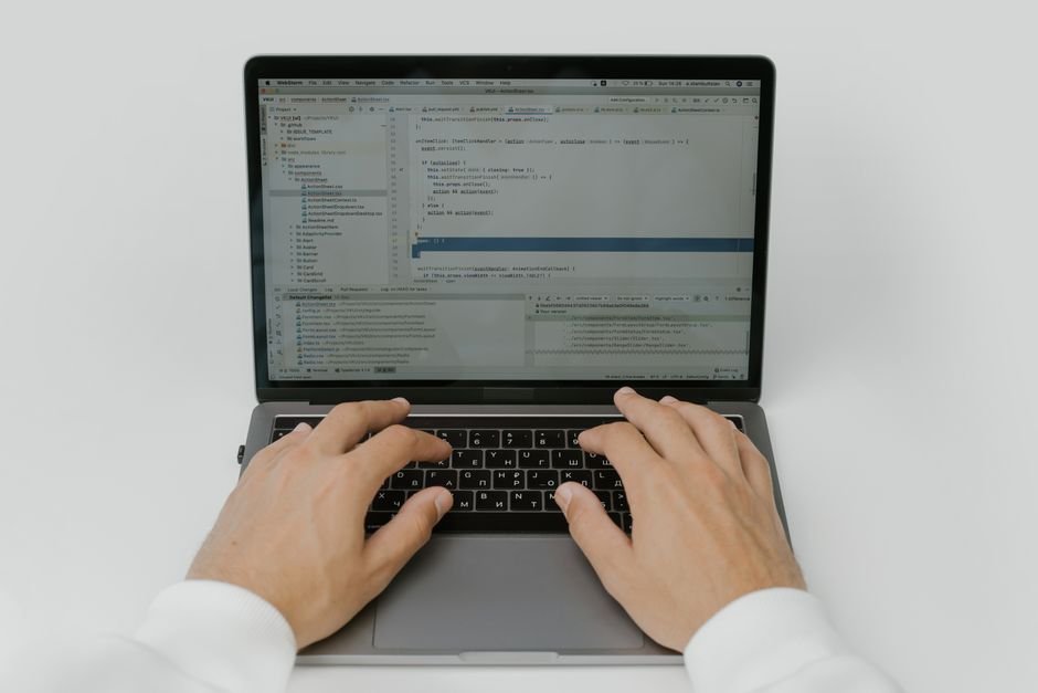 pexels photo 5474295.jpg A medical coder's hands are busy typing on a laptop, inputting billing information.