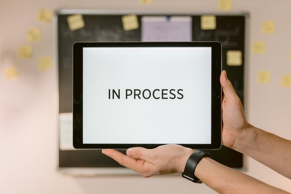 Hands holding a tablet showing an 'In Process' status for a medical claim appeal.