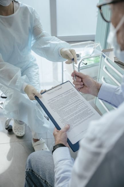 Patient in a medical office signing an advance beneficiary notice form for medical services.